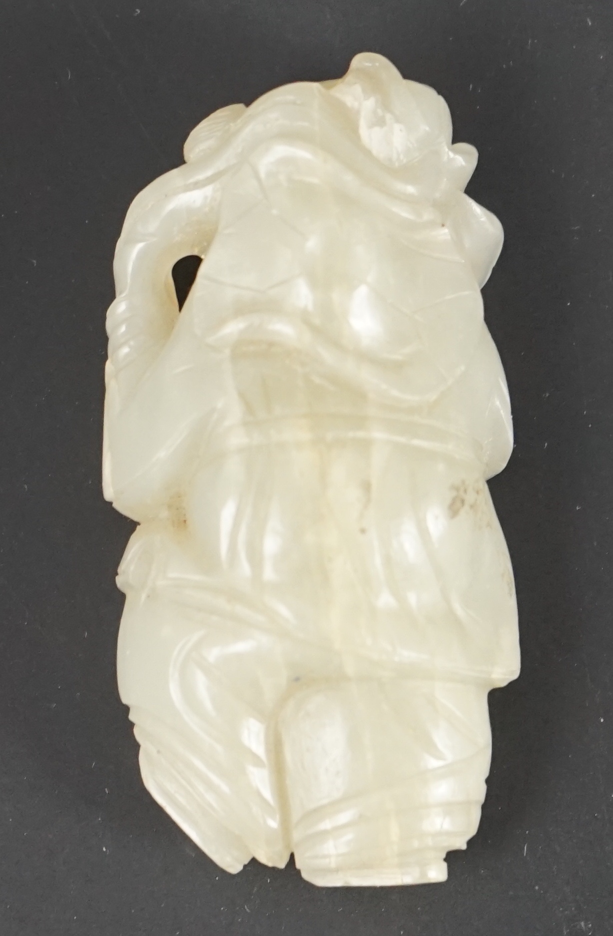 A Chinese celadon jade figure of a boy holding a lotus sprig, 19th century 5.2 cm high